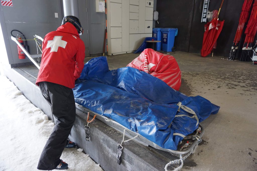 OLD SCHOOL TABOGGAN STILL USED IN DIFFICULT TO GET TO TERRAIN. OTHERWISE THE NEW PATIENT TRAILER TOWED BY THE SKI-DOO IS USED FOR THE SAKE OF EFFICIENCY